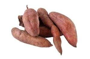 A pile of five sweet potatoes on a white background