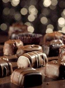 Variety of chocolate candies on a dark background with bokeh lights