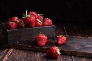 Wooden crate of strawberries on a wooden table